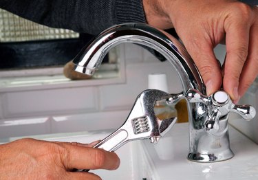 person repairing a faucet