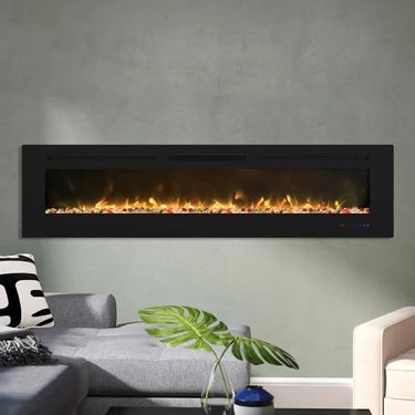 A built-in rectangular fireplace on a gray, minimalist wall