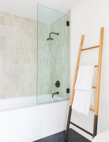 neutral bathroom with wooden ladder as towel rack