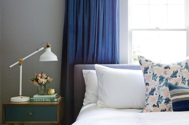 Bedroom with dark gray walls and navy blue curtains.