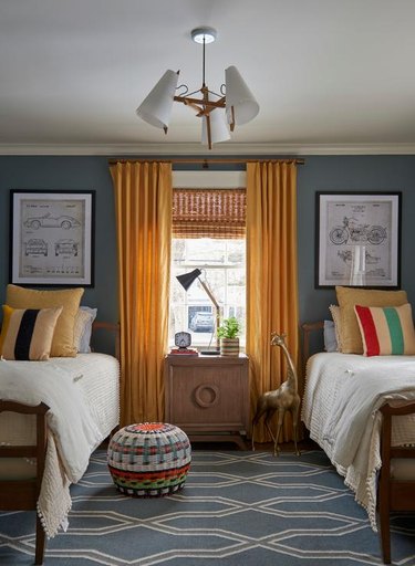 Bedroom with dark gray walls and yellow curtains.