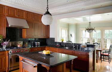 kitchen with cherry wood cabinets, black countertops, and white walls