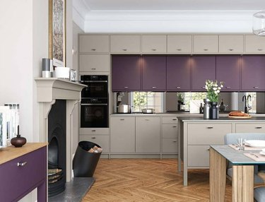 Kitchen with light gray and purple cabinets, wood floors, black appliances.