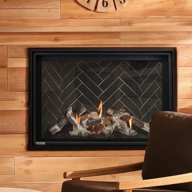 A direct vent fireplace with a black insert that has a herringbone pattern