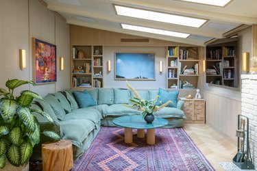 media room with turquoise sectional sofa and purple rug under skylights