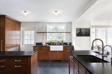 kitchen with cherry wood cabinets, black countertops, and white walls