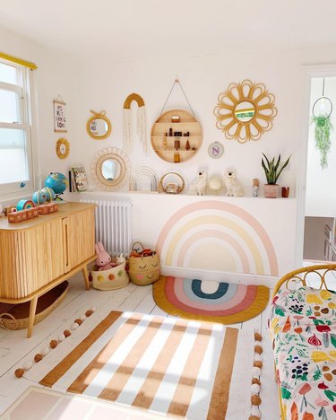 colorful nursery with hand painted rainbow wall mural