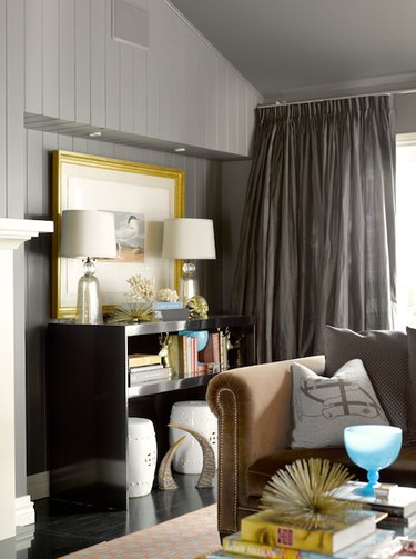 Living room with brown velvet sofa, gray walls, and charcoal curtains
