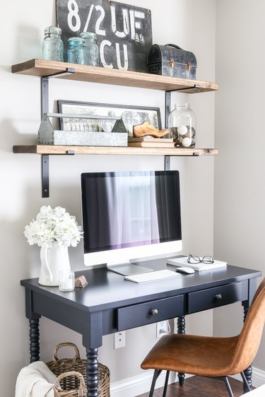 corner home office with vintage farmhouse decor on wood floating shelves