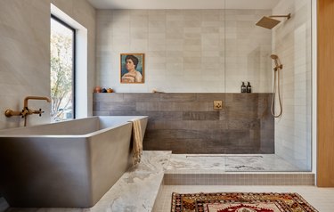 primary bath with soaking tub and a work of art on the wall