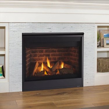 A direct vent gas fireplace with a brick interior and a stone exterior