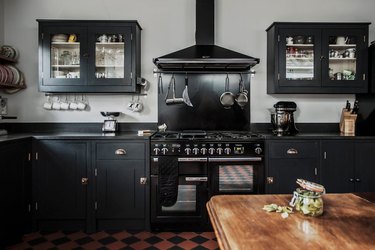 black kitchen cabinets with black appliances gray walls