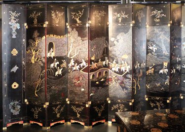 black folding screen with scene of daily life