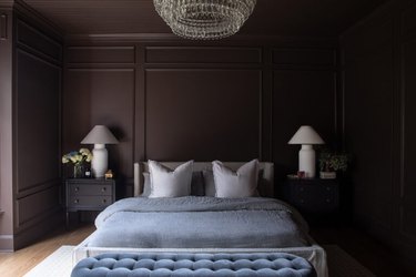 brown bedroom with light blue bedding and bench