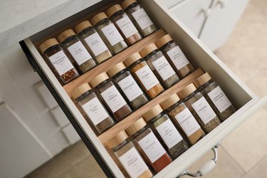 DIY spice drawer organizers with glass spice jars and wooden tops
