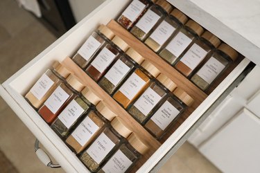 DIY spice drawer organizers with glass spice jars and wooden tops