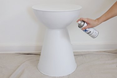 Spraying white primer all over side table