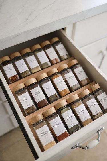 DIY spice drawer organizers with glass spice jars and wooden tops