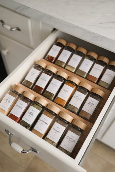 DIY spice drawer organizers with glass spice jars and wooden tops