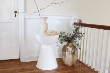 DIY plaster side table styled with vase, branches and book