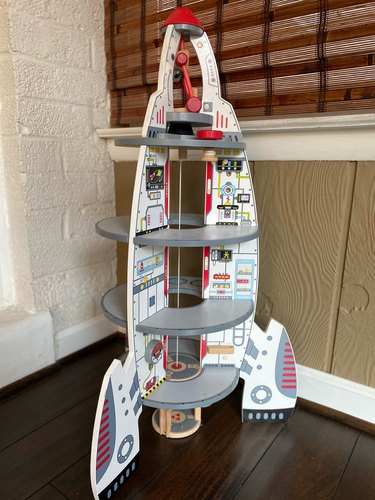 Rocket ship toy in corner of room