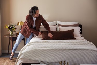 jake arnold arranging parachute bedding collection on bed