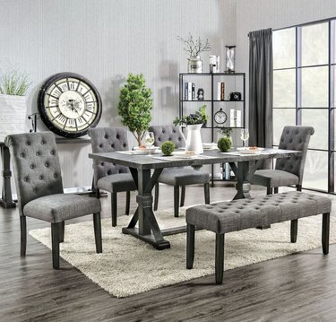 Gray dining table with gray upholstered chairs and bench