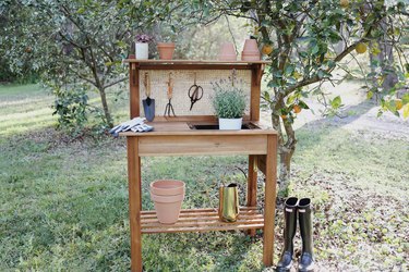 DIY cane webbing potting bench with garden tools and terra cotta pots