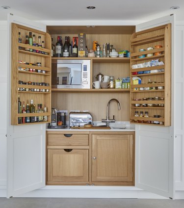 appliance garage meets pantry with sink, microwave and spice rack doors