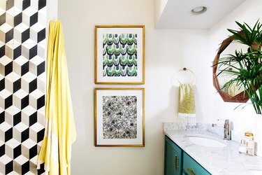 bohemian bathroom with pattern tile on accent wall and green vanity cabinet topped with plant