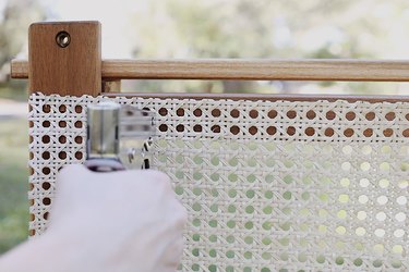 Stapling cane webbing to potting bench with staple gun