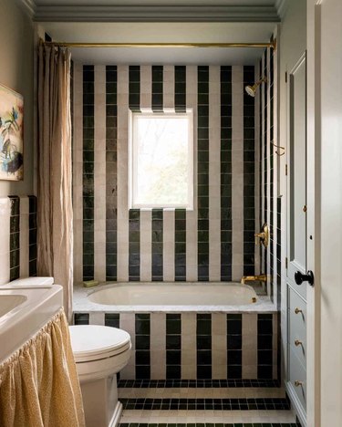 black and white zellige tile striped bathroom with linen shower curtain and floral sink skirt