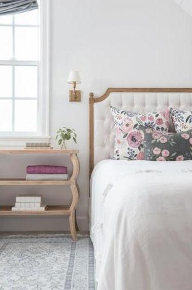 Farmhouse Chic Bedroom Ideas with decorative rug, table with shelves, bed with upholstered headboard
