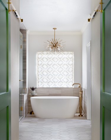 midcentury modern bathroom idea with sputnik-style chandelier above bathtub