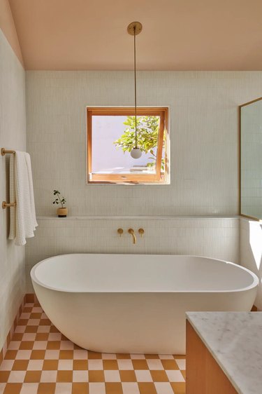 midcentury modern bathroom design with pink ceiling and white tile on the walls and checkerboard floor tile