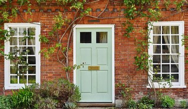 red brick home with mint green door