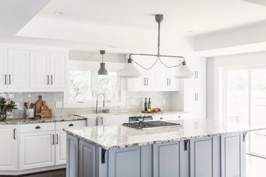 Alaska granite countertops in a  modern farmhouse kitchen with blue and white cabinets