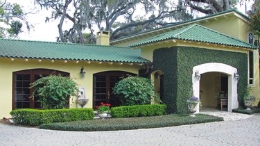a Florida home with yellow exterior paint and a green roof.