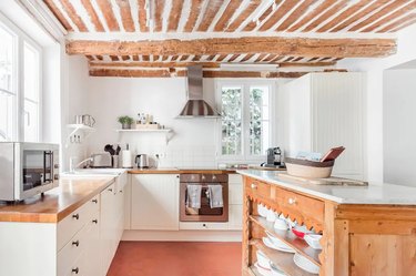 white french country style kitchen with exposed wooden beams