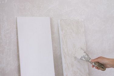 Applying Roman Clay to primed shelves with putty knife