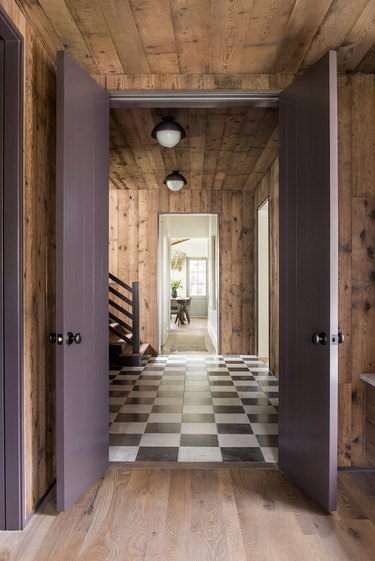 foyer with wood paneling and plum doors