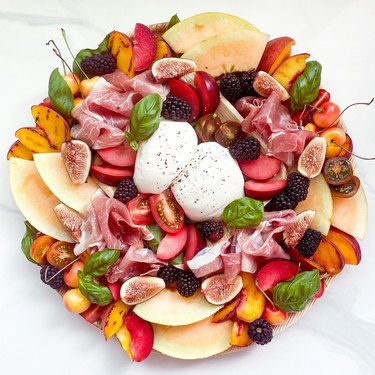 Burrata board with nectarines, berries, and tomatoes