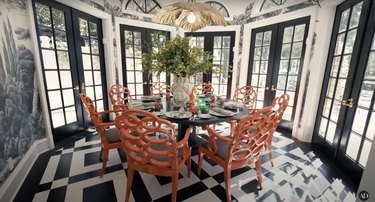 RuPaul's dining room featuring a black and white color scheme, curlicue orange chairs, and nature wallpaper.