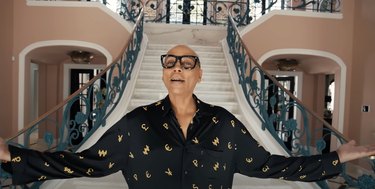 RuPaul coming down the main stairway in his Beverly Hills mansion.