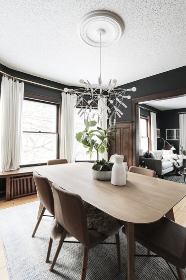 dining room with black walls and wood paneling