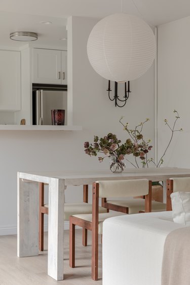 The dining room with HAY rice paper shade hanging above table and vintage teak chairs