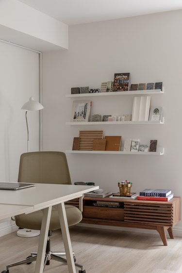 office area with picture frame ledges on the wall above a wooden cabinet