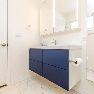 bathroom space with vanity with blue fronts