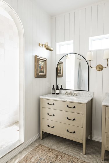 brass picture light and wall sconce in traditional bathroom