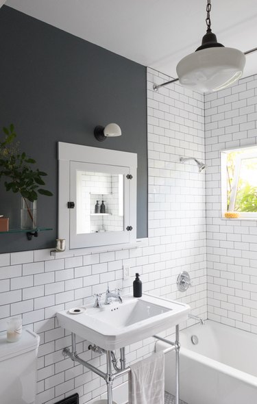 milk glass pendant light with subway tile in traditional bathroom